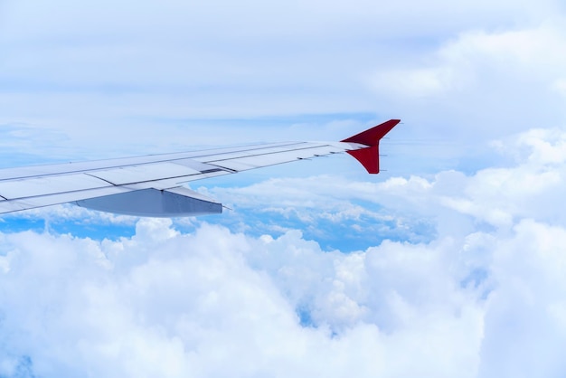 Пейзаж из окна самолета, видя крыло самолета, белые облака и голубое небо
