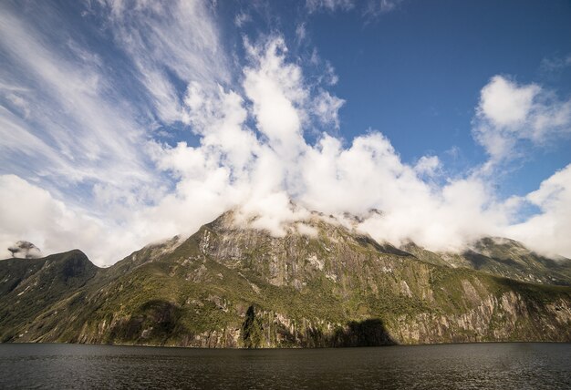 scenery of huge green mountain with fog or mist on top of the mountain peak