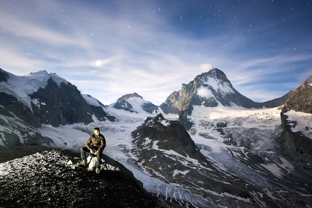 Scenery of mountains man sitting on stone