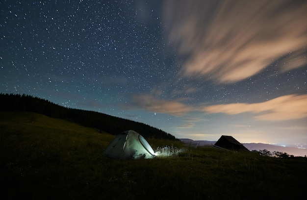 Scenery of tent near forest at night