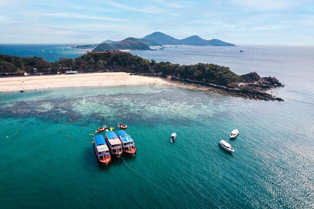 Scenery of tropical sea beach with boat anchored and tourist with leisure activity in summer on sunny day at koh larn