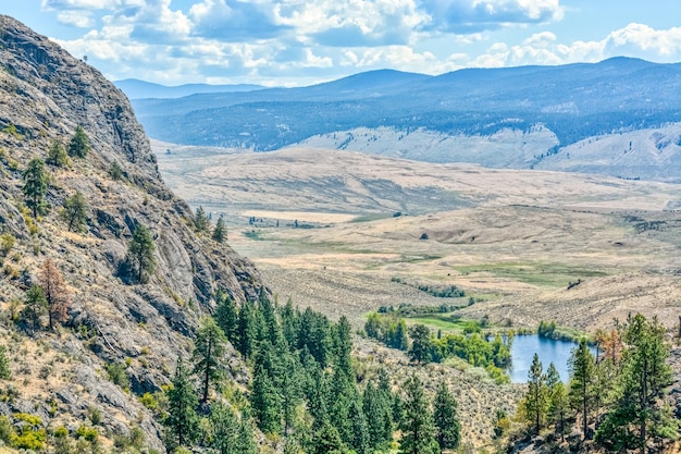 Scenery view of a valley with small lake downhill on a bright sunny day