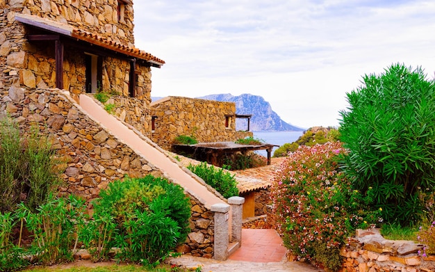 Scenery with House and cottages at Capo Coda Cavallo, San Teodoro in Olbia-Tempio province, Sardinia island, in Italy. Mediterranean sea at the background. Tavola island