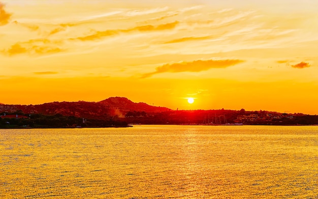 コスタスメラルダの地中海で日の出または日没のポルトロトンドの風景。夏にイタリアのサルデーニャ島のポルトチェルボ。サルデーニャの風景。サルデーニャオルビア州。ミクストメディア。