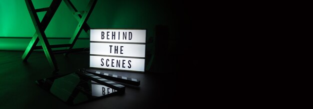 behind the scenes letterboard text on lightbox or cinema light box. movie clapperboard megaphone