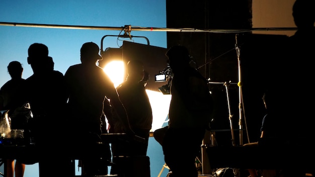 Foto dietro le quinte dello studio di ripresa di produzione video in silhouette che ha professionisti