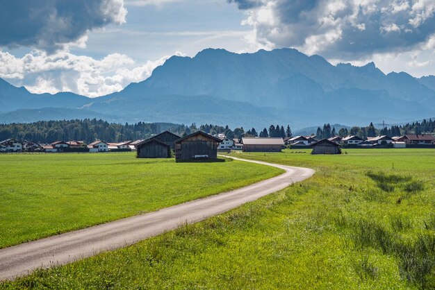 Scenic Alpine landscape with a green field and rural houses in the distance Upper Bavaria Germany