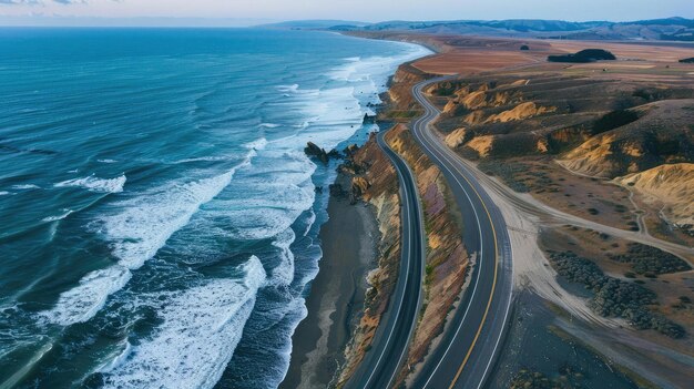 写真 波が岩の崖や砂浜にぶつかる海岸線に囲まれた美しい沿岸道路