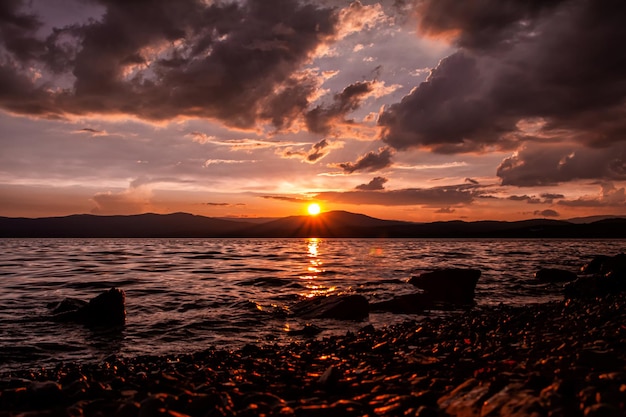 Tramonto cremisi scenico su un bellissimo lago