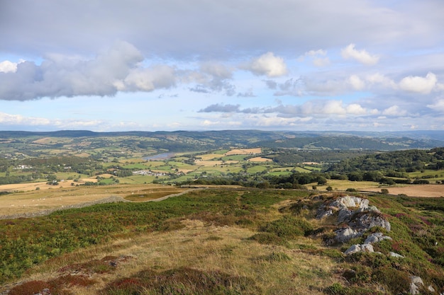 Photo scenic landscape with rolling hills green grass and fluffy clouds in the sky wales