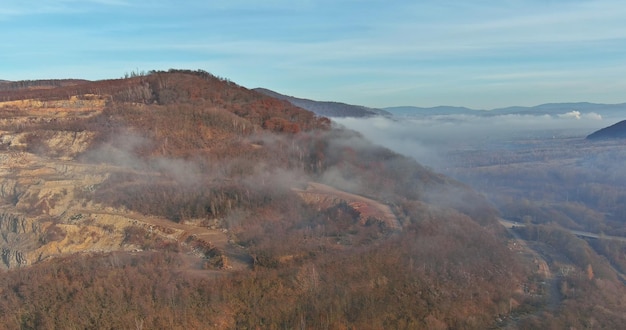 Scenic mountain landscape of aerial view on autumn nature forest in fog