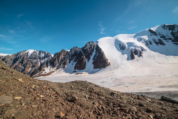 Scenic mountain landscape with large glacier in sunlight Awesome snowy scenery with glacial tongue under cirrus clouds Beautiful alpine view to snow mountain tops at very high altitude in sunny day