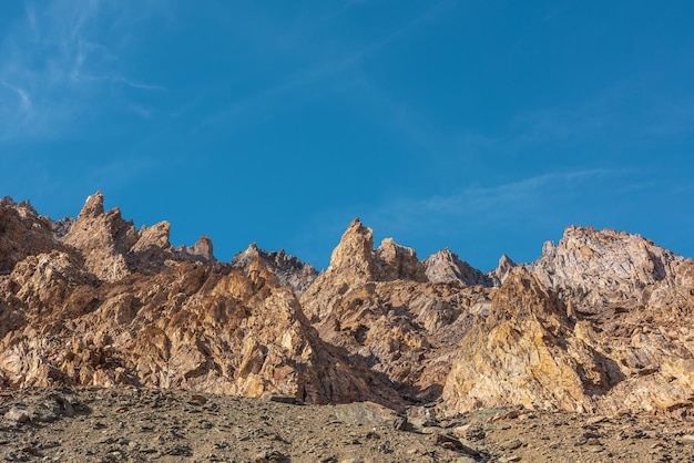 Scenic mountain landscape with sharp rocks under blue sky in sunny day Colorful scenery with gold sunlit sharp rocky mountains Sharp rocks in bright sun High rocky mountains in golden sunlight