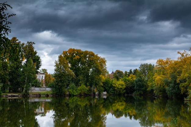 Scenic pond in autumn park in cloudy weather