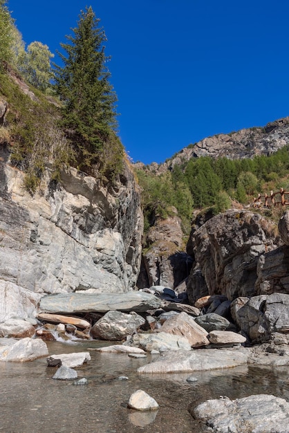 Scenico stagno acqua limpida sentiero di ringhiera in legno da lillaz cascata verticale cogne aosta italia