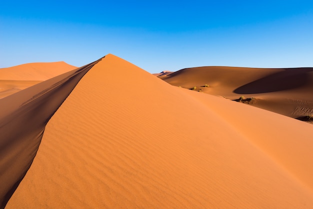 Scenic ridges of sand dunes in Sossusvlei, Namib Naukluft National Park, best tourist and travel attraction in Namibia.