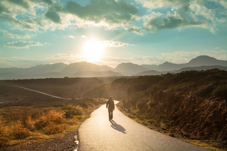 Photo scenic road in the mountains. travel background. man going on sunrise background.