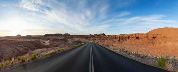 Scenic road in red rock mountains in the desert at colorful sunrise