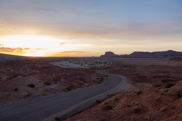 Scenic road in red rock mountains in the desert at sunrise