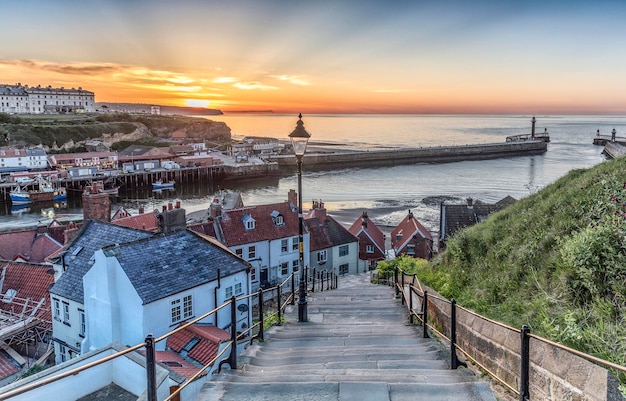 Photo scenic view of the 199 steps spot in whitby england on a sunset sky background