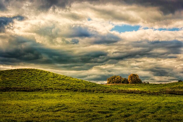 Photo scenic view of agricultural field against dramatic sky