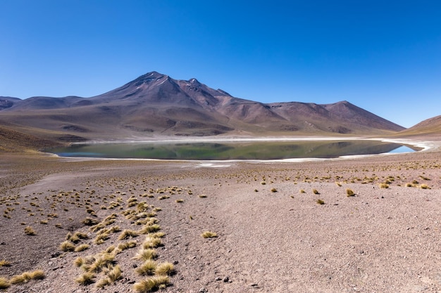 Scenic view of arid landscape against clear blue sky