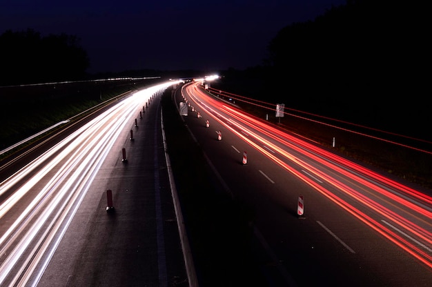 Scenic view of an asphalt road with light trails at night