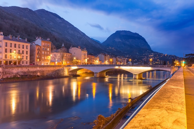 프랑스 그르노블(Grenoble)의 배경에 프랑스 알프스(French Alps)가 있는 생 앙드레 대학(Collegiate Church of Saint-Andre)의 이세레(Isere) 강과 다리 유역의 아름다운 전망