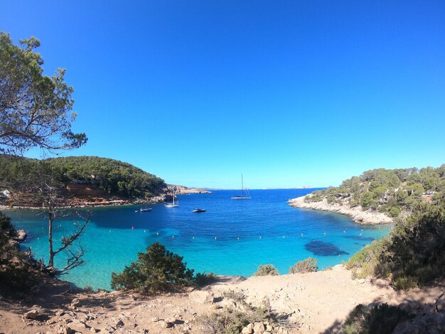 Scenic view of bay against clear blue sky