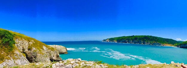 Scenic view of bay against clear blue sky