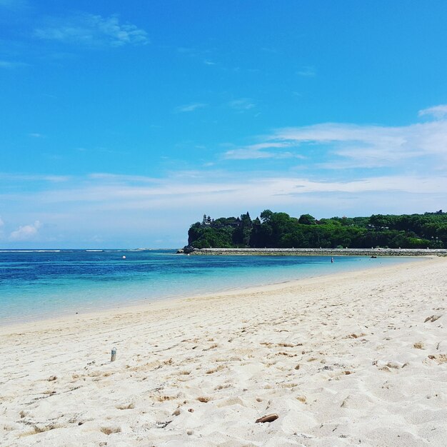 Scenic view of beach against blue sky