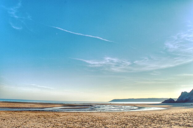 Scenic view of beach against blue sky