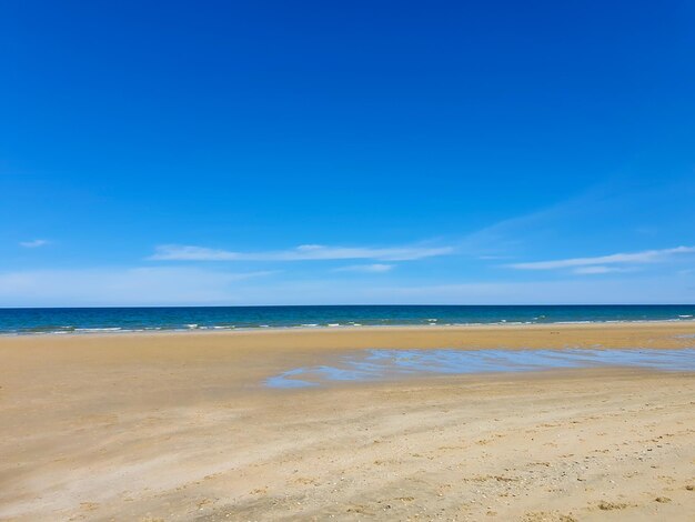 Scenic view of beach against blue sky