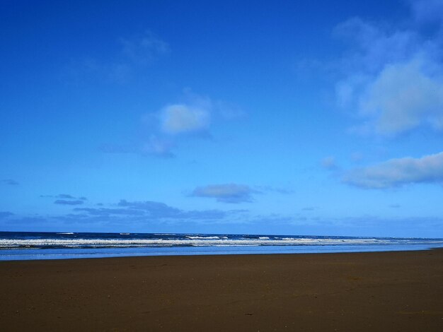 Scenic view of beach against blue sky