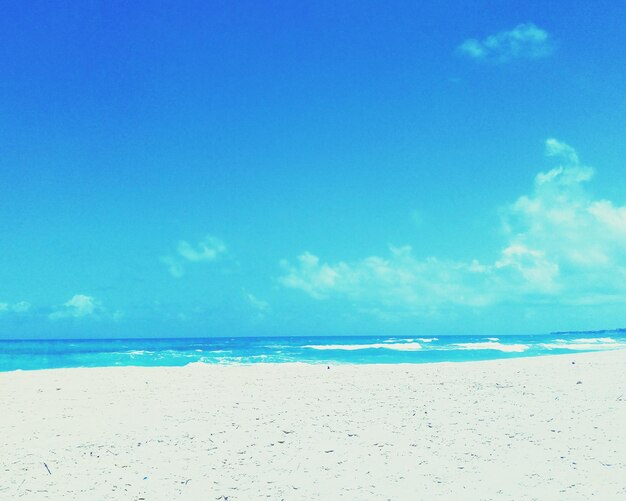 Scenic view of beach against blue sky