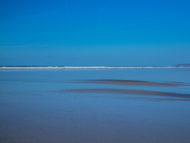 Scenic view of beach against blue sky