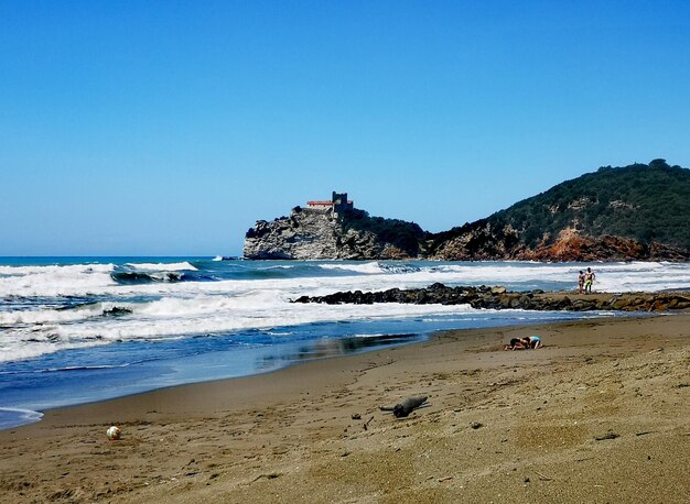 Scenic view of beach against clear blue sky