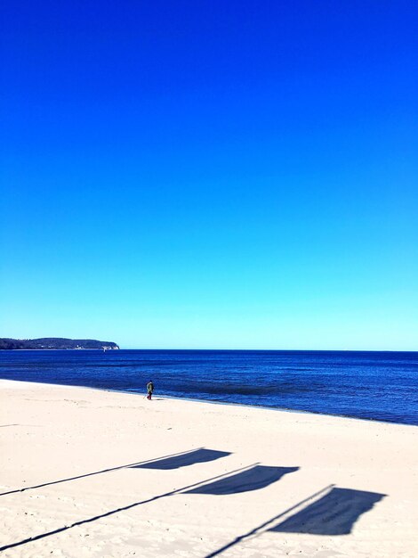 Scenic view of beach against clear blue sky