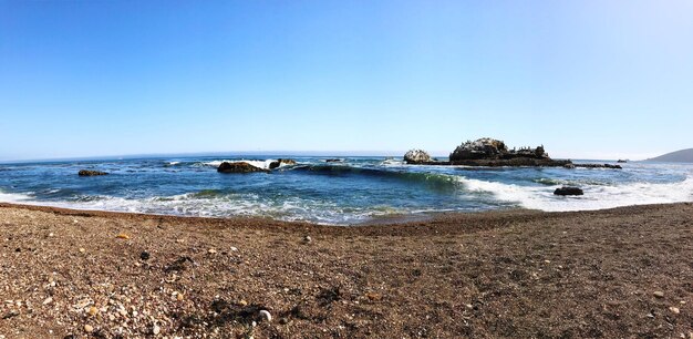 Scenic view of beach against clear blue sky