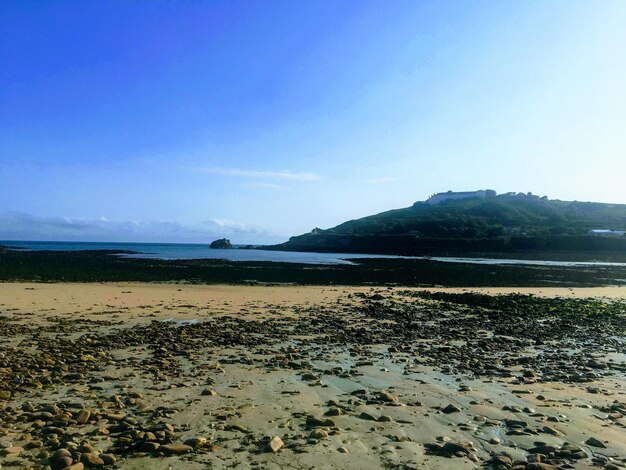 Scenic view of beach against clear blue sky