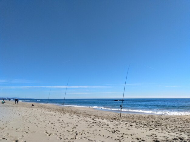 Scenic view of beach against clear blue sky