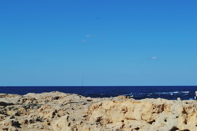 Scenic view of beach against clear blue sky