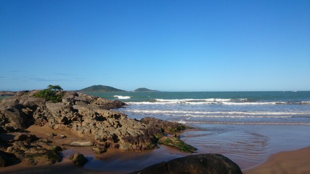 Scenic view of beach against clear blue sky