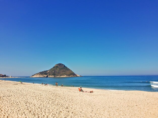 Scenic view of beach against clear blue sky