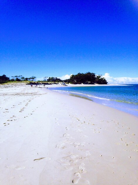 Scenic view of beach against clear blue sky