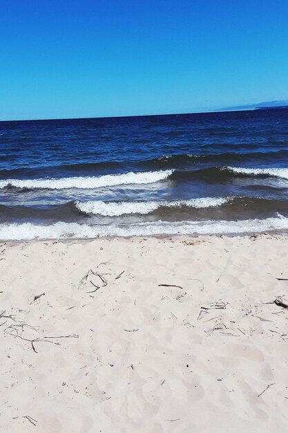 Scenic view of beach against clear blue sky