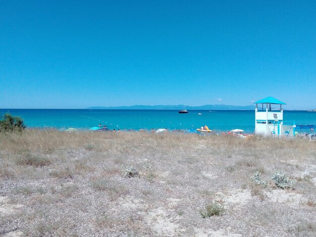 Scenic view of beach against clear blue sky