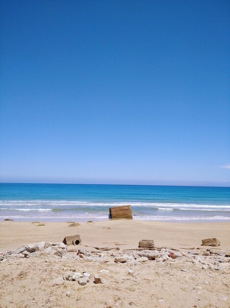 Scenic view of beach against clear blue sky