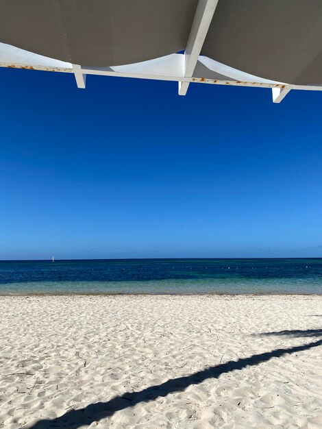 Scenic view of beach against clear blue sky