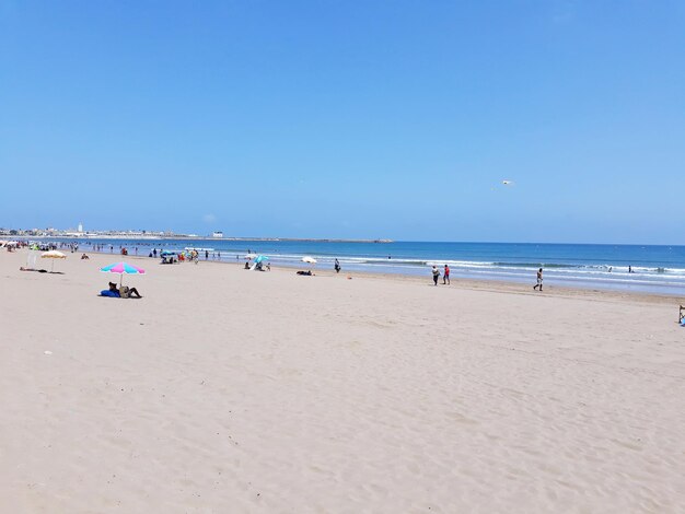 Scenic view of beach against clear blue sky